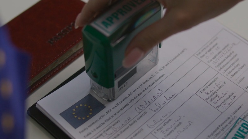 A hand stamping an official document at a desk