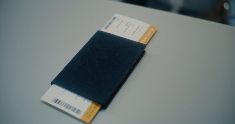 A U.S. passport with an airline ticket resting on a clean desk